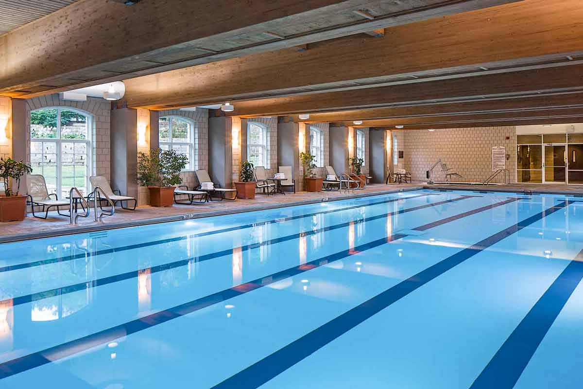 A very large indoor pool with reclining chairs and accessible entrances to the pool