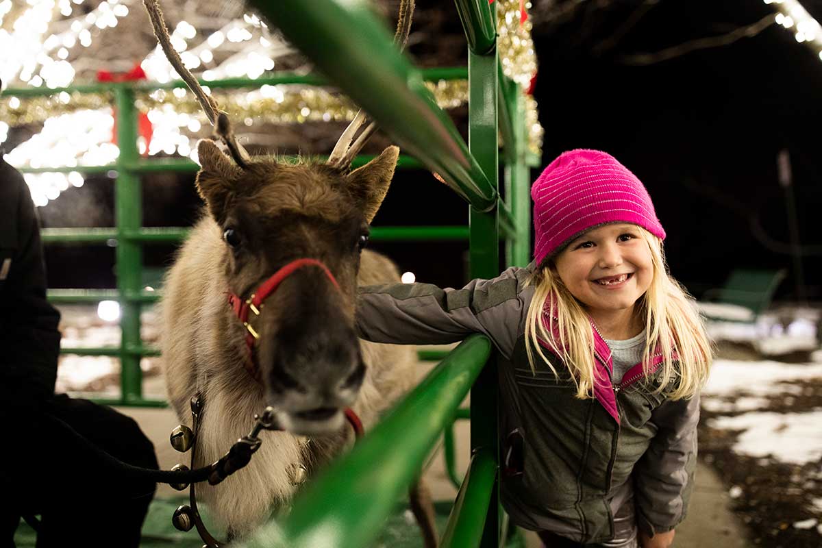 Little girl with reindeer, Christmas time at Arbor Day Farm